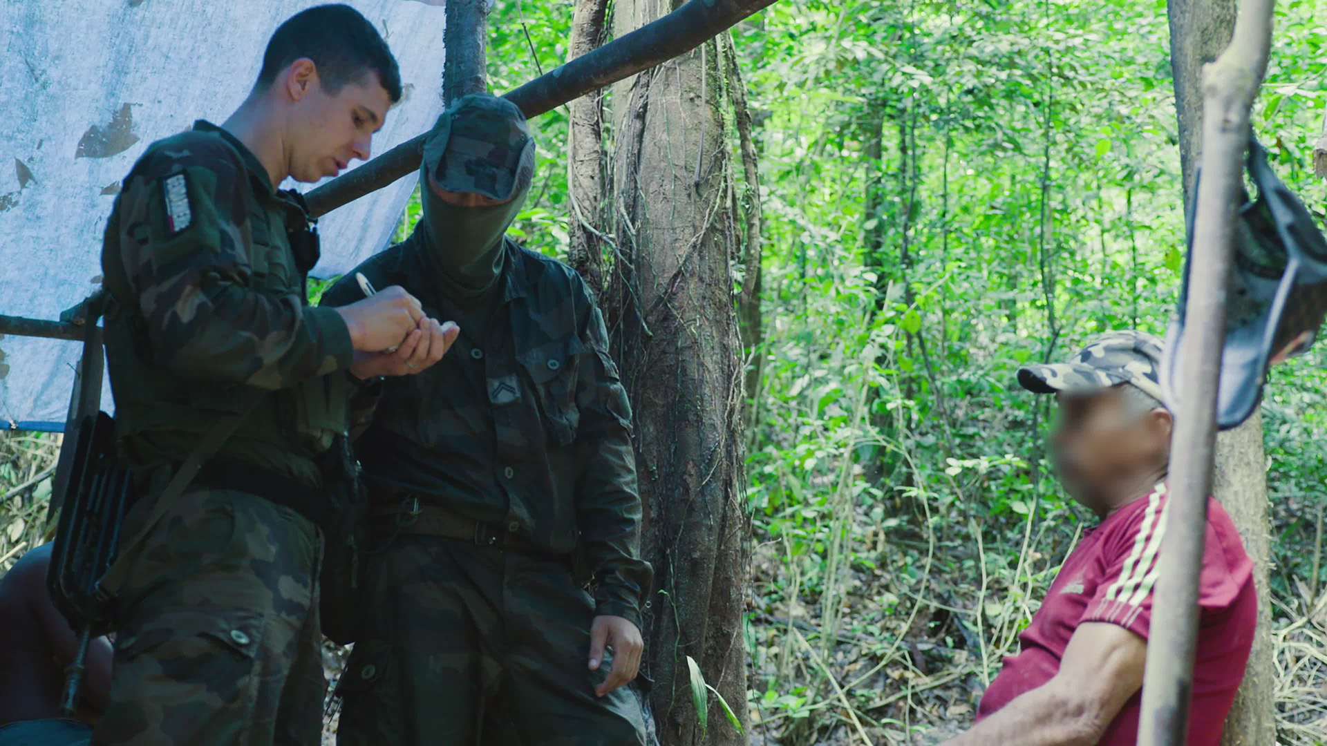 The gendarme gets the details of a suspected member of a gold mining gang