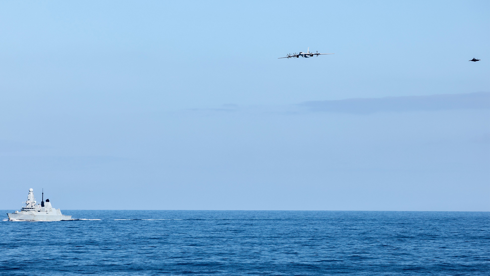 HMS Duncan keeps a lookout skyward as one of the two F-35Bs sent to intercept the Tu-142 keeps tabs on the Russian aircraft from the air (Picture: MOD)