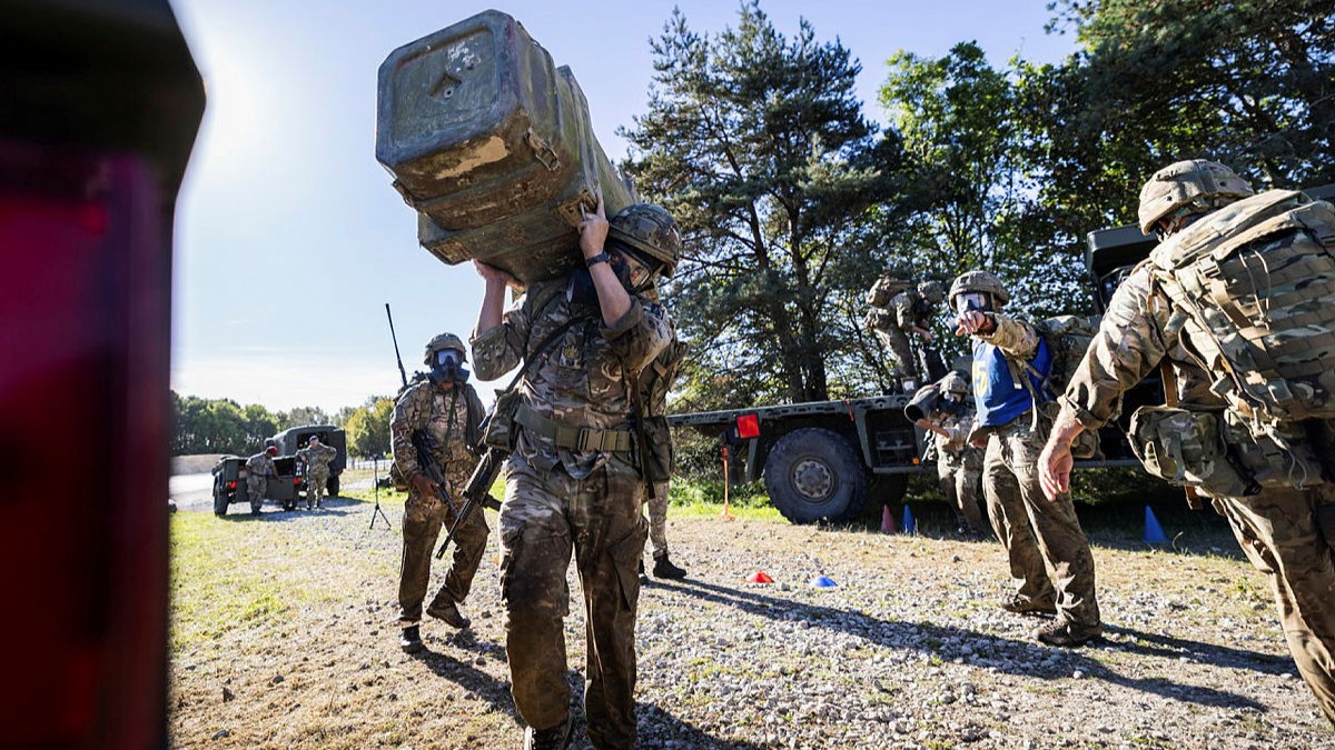 Royal Logistic Corps (RLC) Sergeant Major, WO1 Marquis, carries a large piece of equipment whilst wearing his General Service Respirator (GSR) during the annual RLC Military Skills Competition (Picture: MOD)