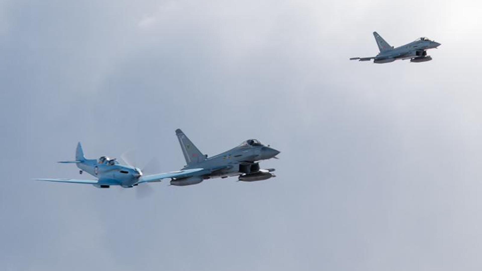The Spitfire flies in loose formation with two IX (B) Squadron Typhoon FGR4s as it makes its way to Prestwick - the jets wear the unit's green bat emblem, a nod to its history as a pioneer of night flying
