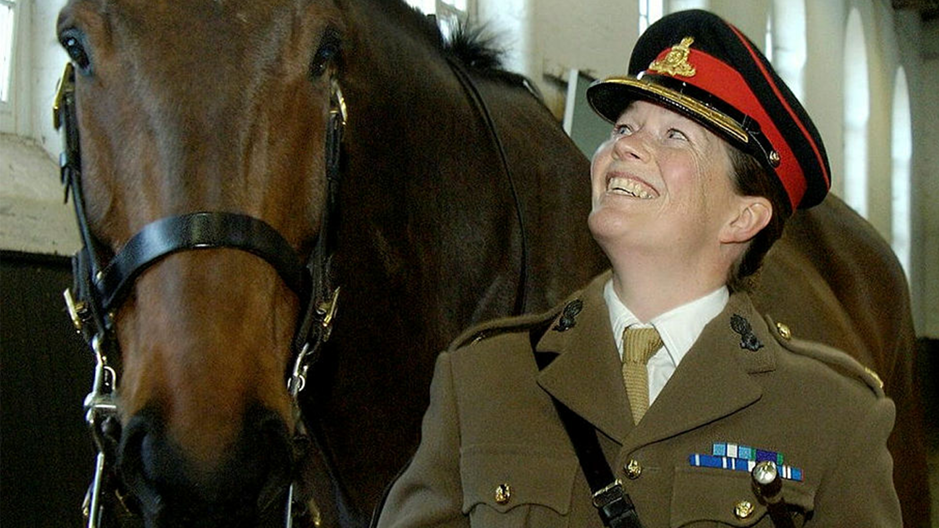 Major Erica Bridge looks up at a horse