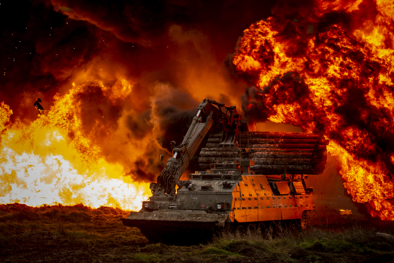 A Trojan armoured vehicle, operated by Royal Engineers, pushes forward to breach enemy positions during a simulated exercise on Salisbury Plain.
