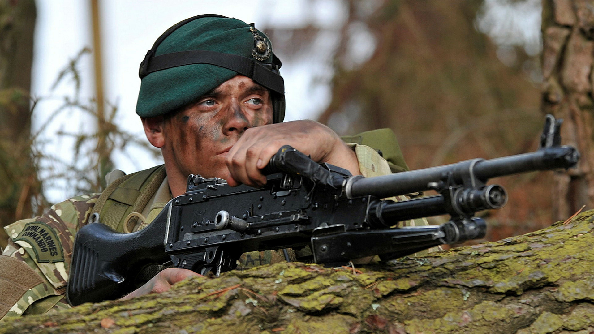 A Royal Marine Commando trains in woodland in Devon 