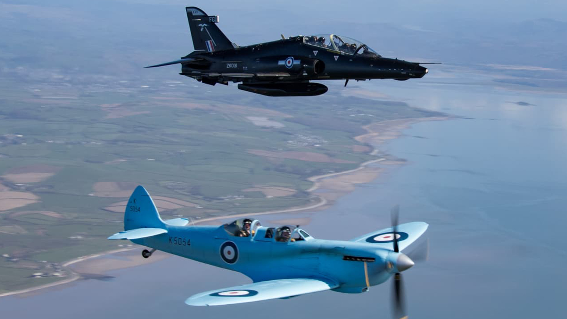 The Spitfire TR9 flies alongside a Hawk T2 as it makes its way from Prestwick to RAF Valley