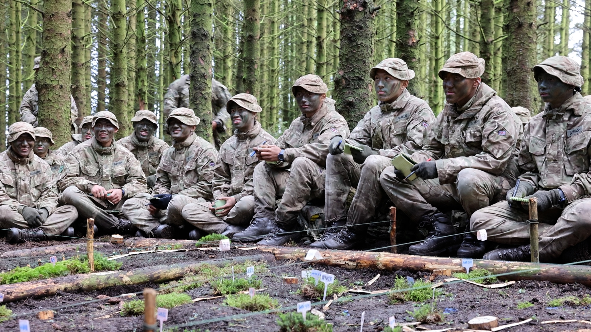 Six Platoon, led by Lieutenant Dominic Gommo, gathers around a model pit built meticulously by the men
