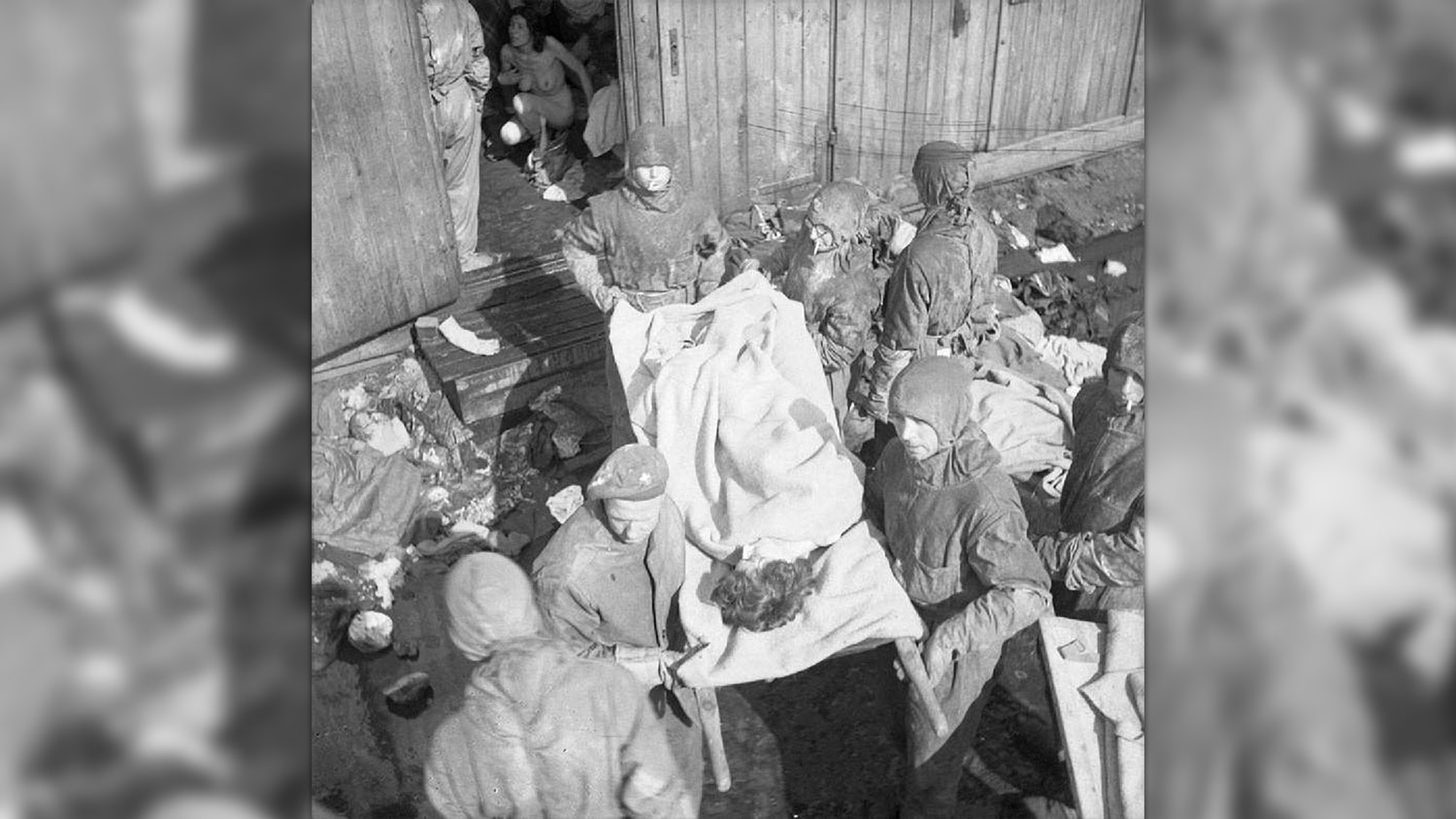 British soldiers wearing hazmat suits as they take the dead and sick from the barracks after the liberation of Bergen-Belsen concentration camp