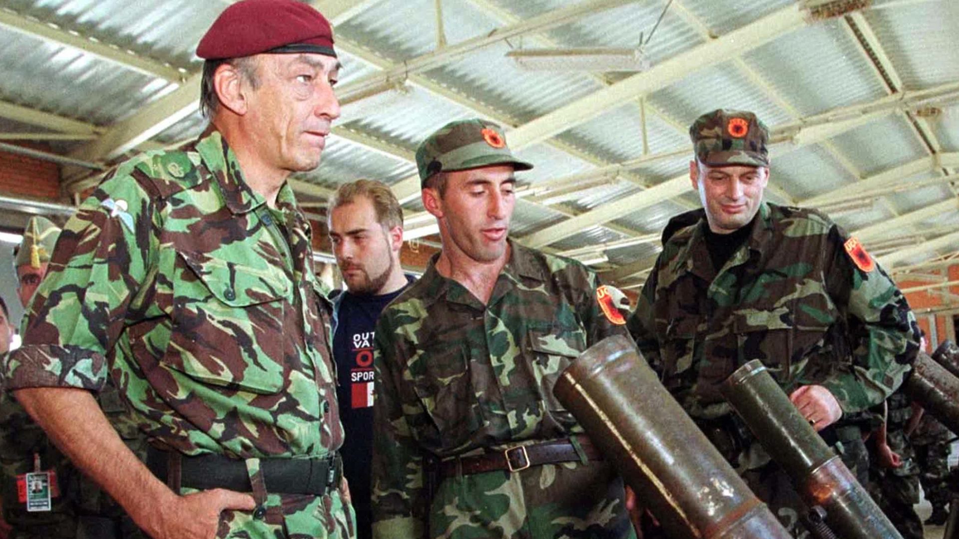 General Mike Jackson and KLA commander Agim Qeku inspect weapons
