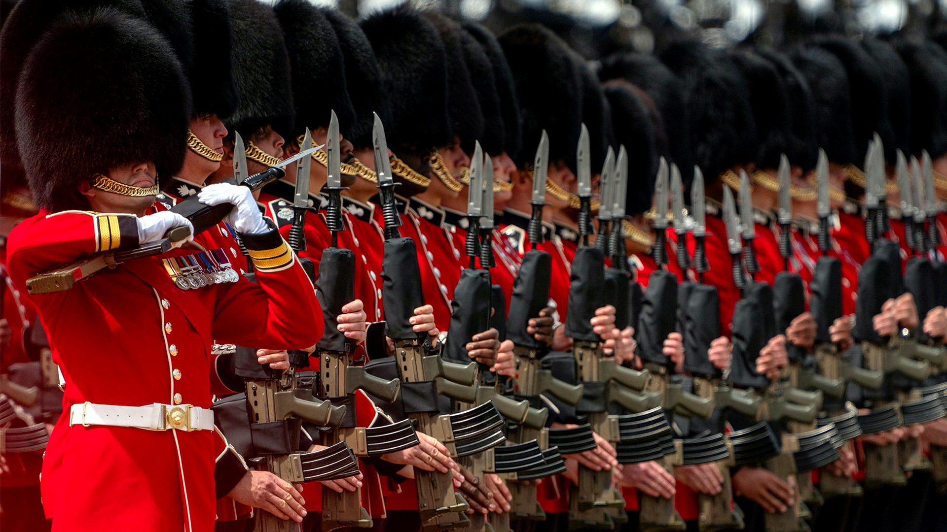 During this portion of the King's Birthday Parade, the right-hand marker was protecting the Colour, holding his SA80 L85 at the high ready position, while the remainder of his guardsmen present arms (Picture: MOD)
