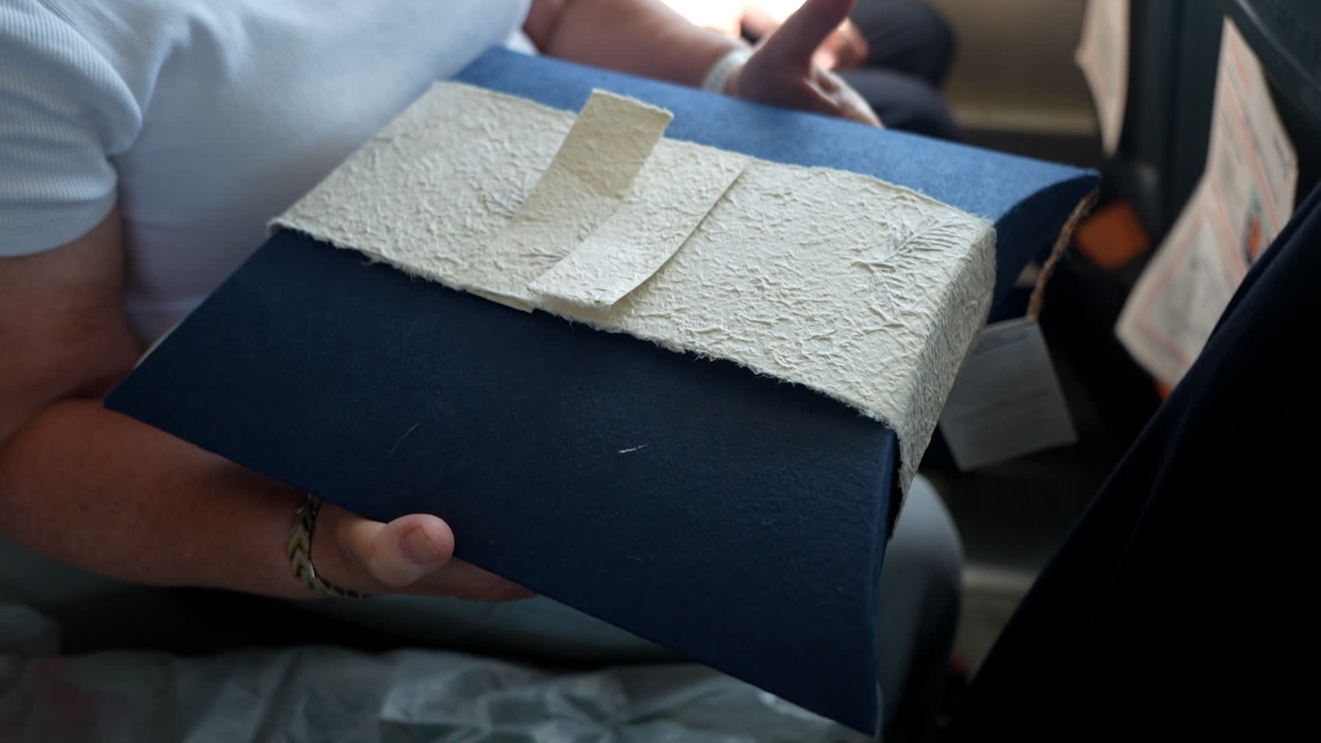 Geraldine Judge shows the cardboard 'pillow' containing her husband's ashes before it's committed to the sea (Picture: BFBS)