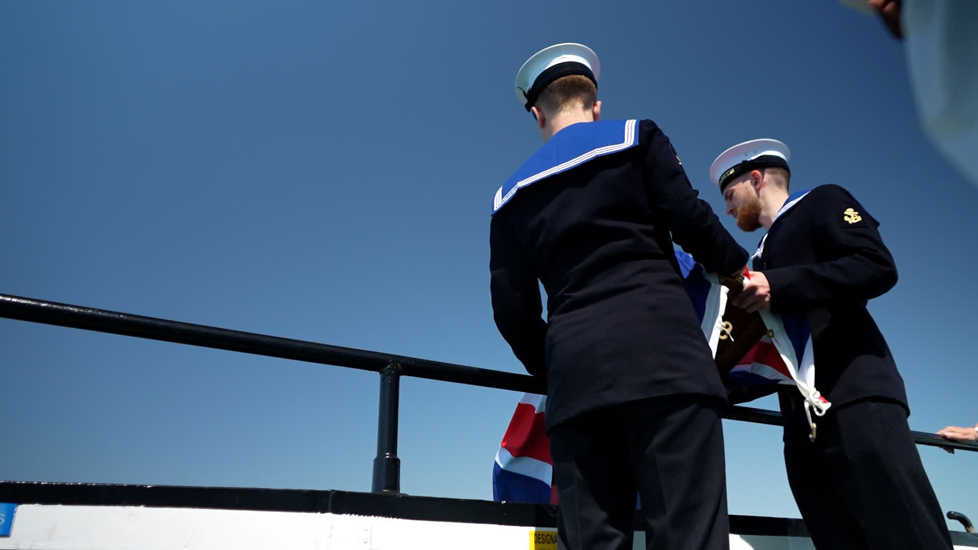 Leading Hand Kurt Tarrant and his fellow committals assistant carry out their duties committing ashes to the sea (Picture: BFBS)