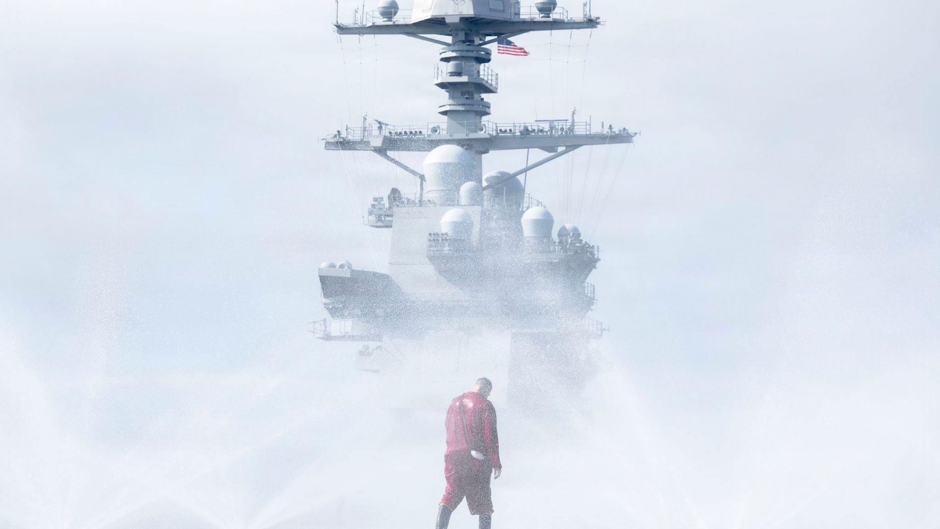 A US sailor conducts a flight deck countermeasure wash-down on USS John F Kennedy (Picture: US Navy on X)