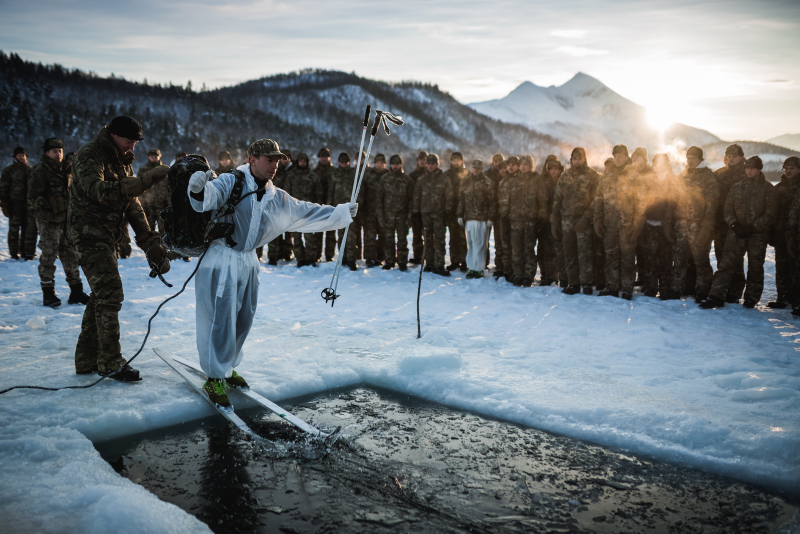 A Royal Marine from 40 Commando, about to slide into icy water, during an ice breaking drill in Norway