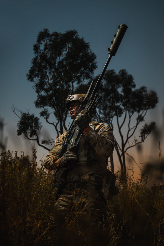 A Royal Marines Commando, patrols through the Australian bush with a .338 sniper rifle at dusk on exercise Talisman Sabre 19 in Queensland, Australia.