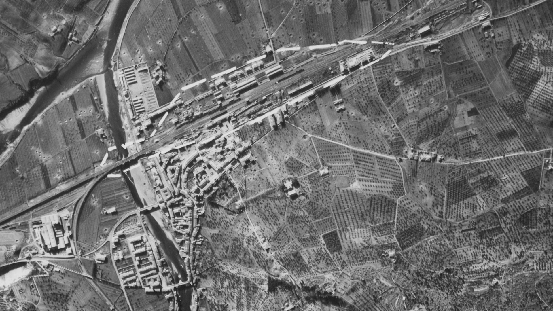 A recce photograph of a damaged railyard in Italy during World War II.