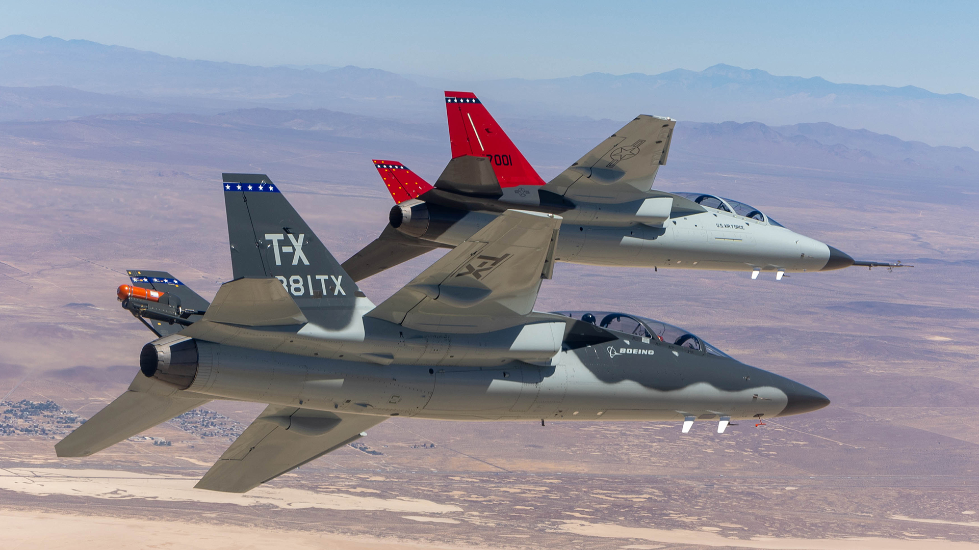 A T-7A Red Hawk (with red tail) and BTX-1 prototype fly together over Edwards Air Force Base - but the T-7 could end up flying over RAF Valley too