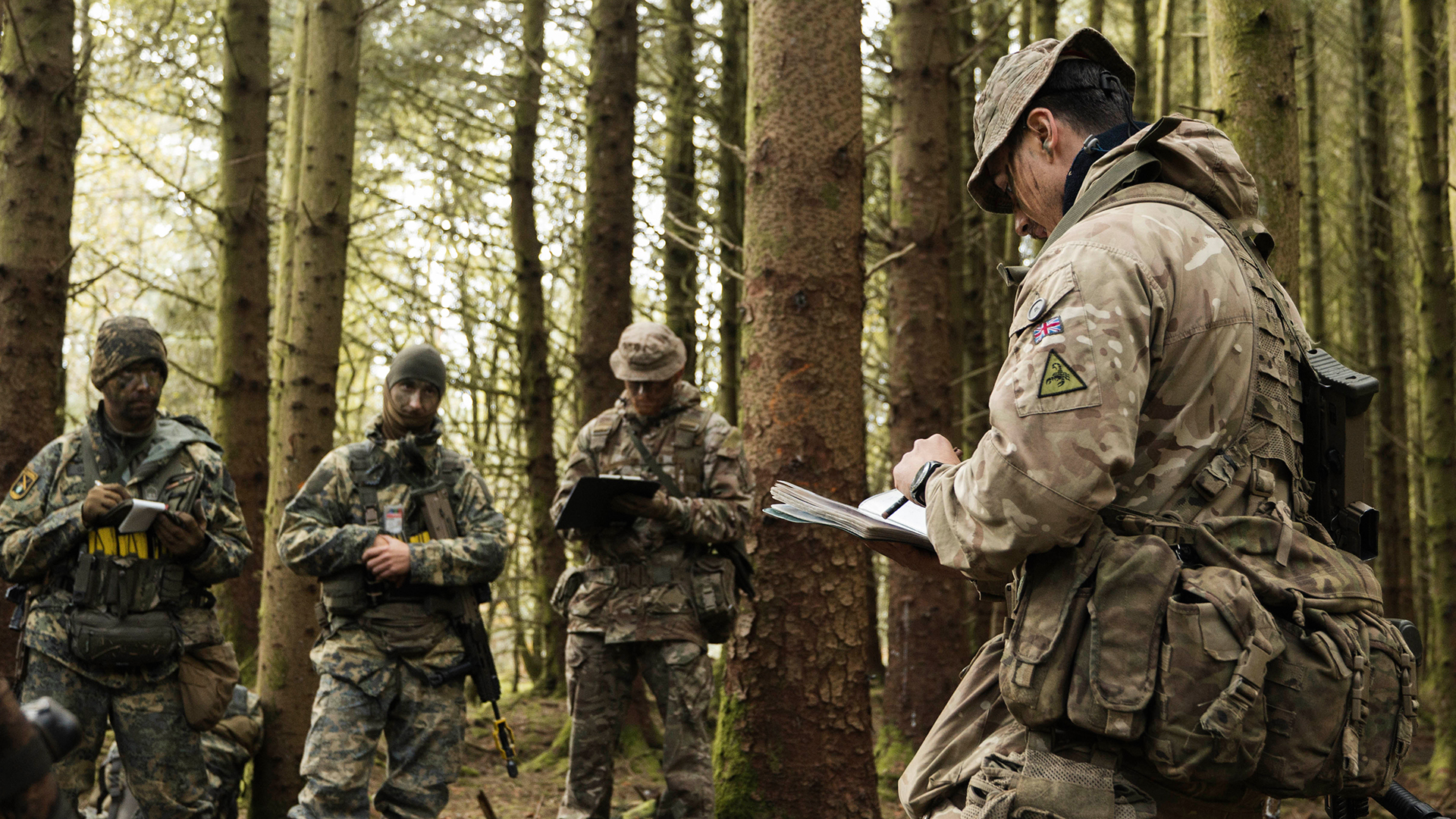 A QDG officer holds an O Group with his mixed British and Austrian team