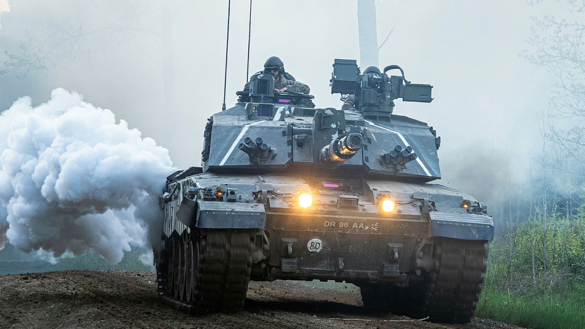 This Challenger 2 is producing concealing smoke as it takes part in Exercise Spring Storm in Estonia - the tanks are being recalled to the UK where many will be upgraded to Challenger 3 specification (Picture: MOD)