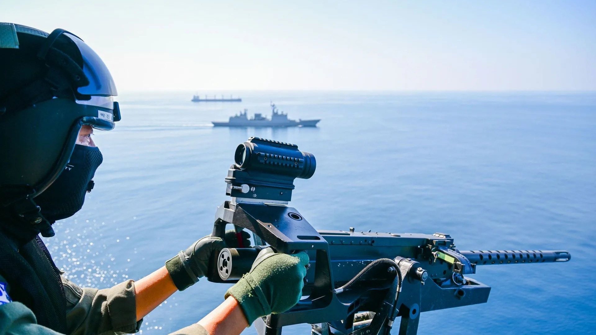 An aircrewman from Roks Dae Jo-Yeong is ready on the gun while escorting merchant shipping with Italy's ITS Bianchi (Picture: Royal Navy)