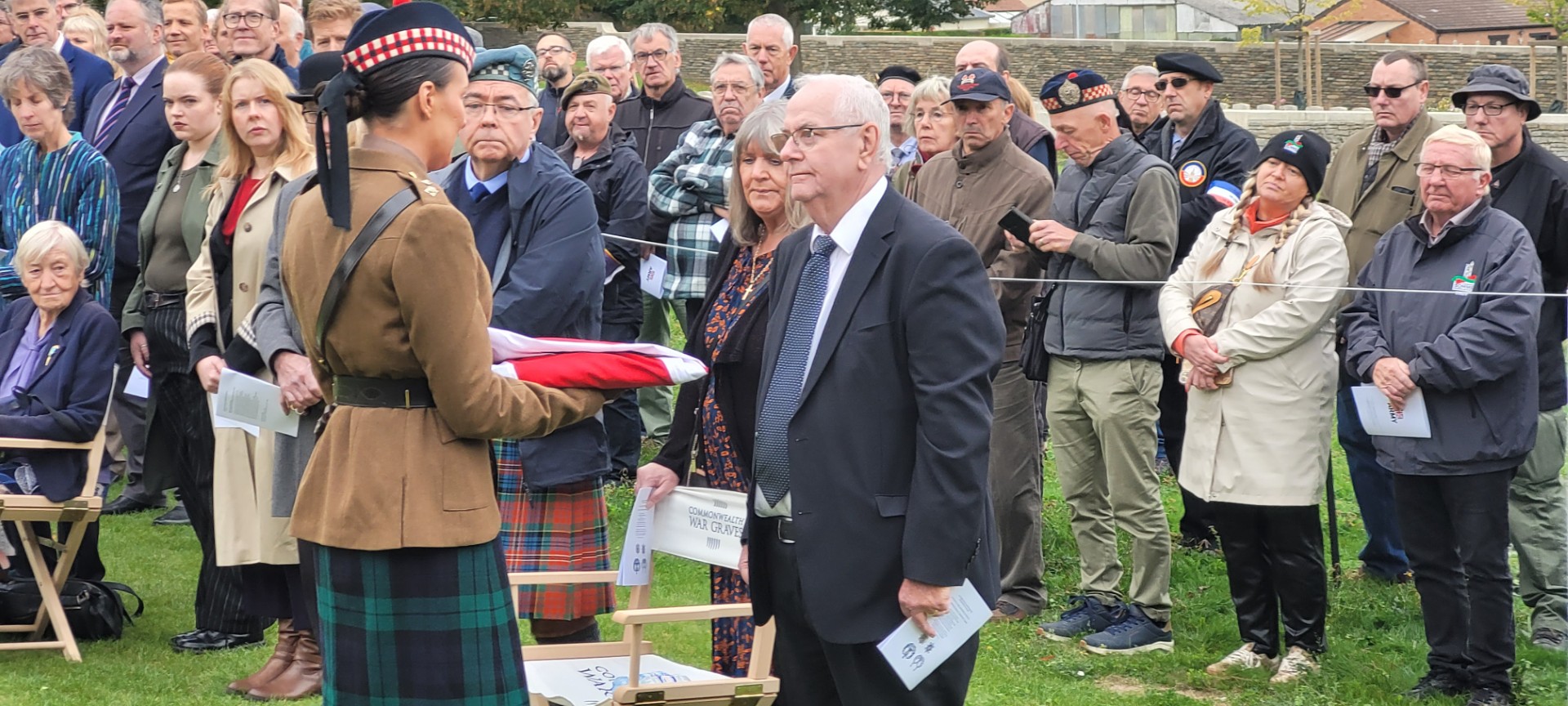 Lieutenant Laura Donovan presents the Union Jack to Alistair McPherson, great-nephew of LCpl Gordan McPherson