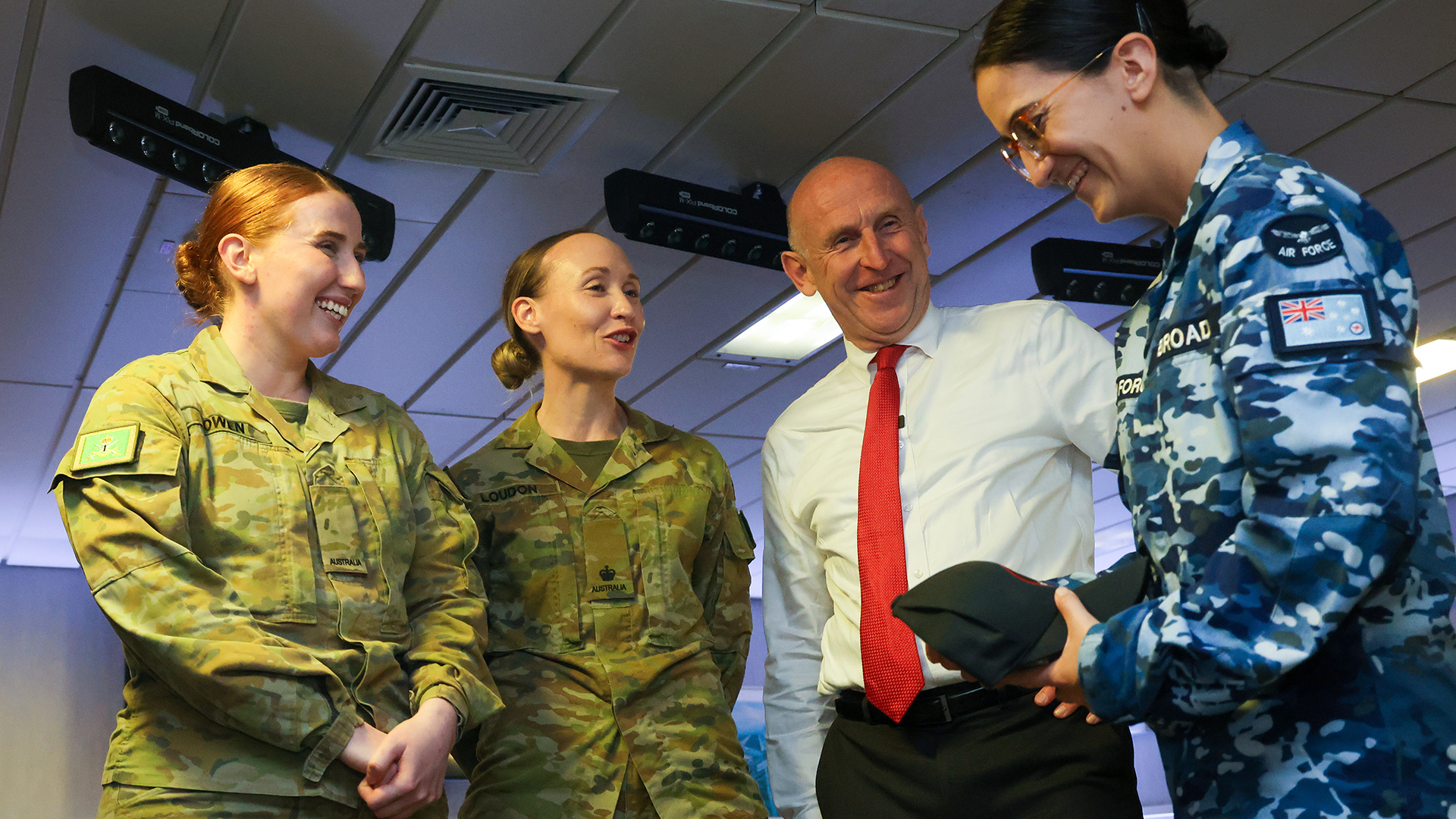 Mr Healey shared a lighthearted moment with some Australian service personnel while aboard HMS Prince of Wales.