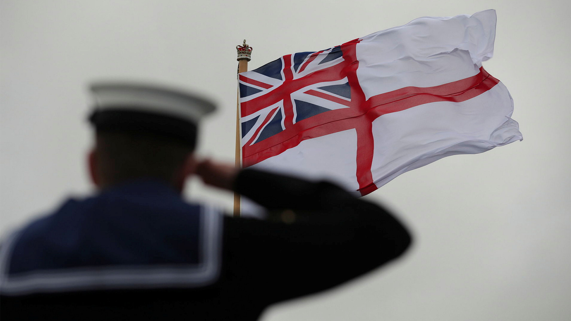 A sailor salutes as the White Ensign is raised on board the Royal Navy's flagship, HMS Prince of Wales (Picture: MOD)