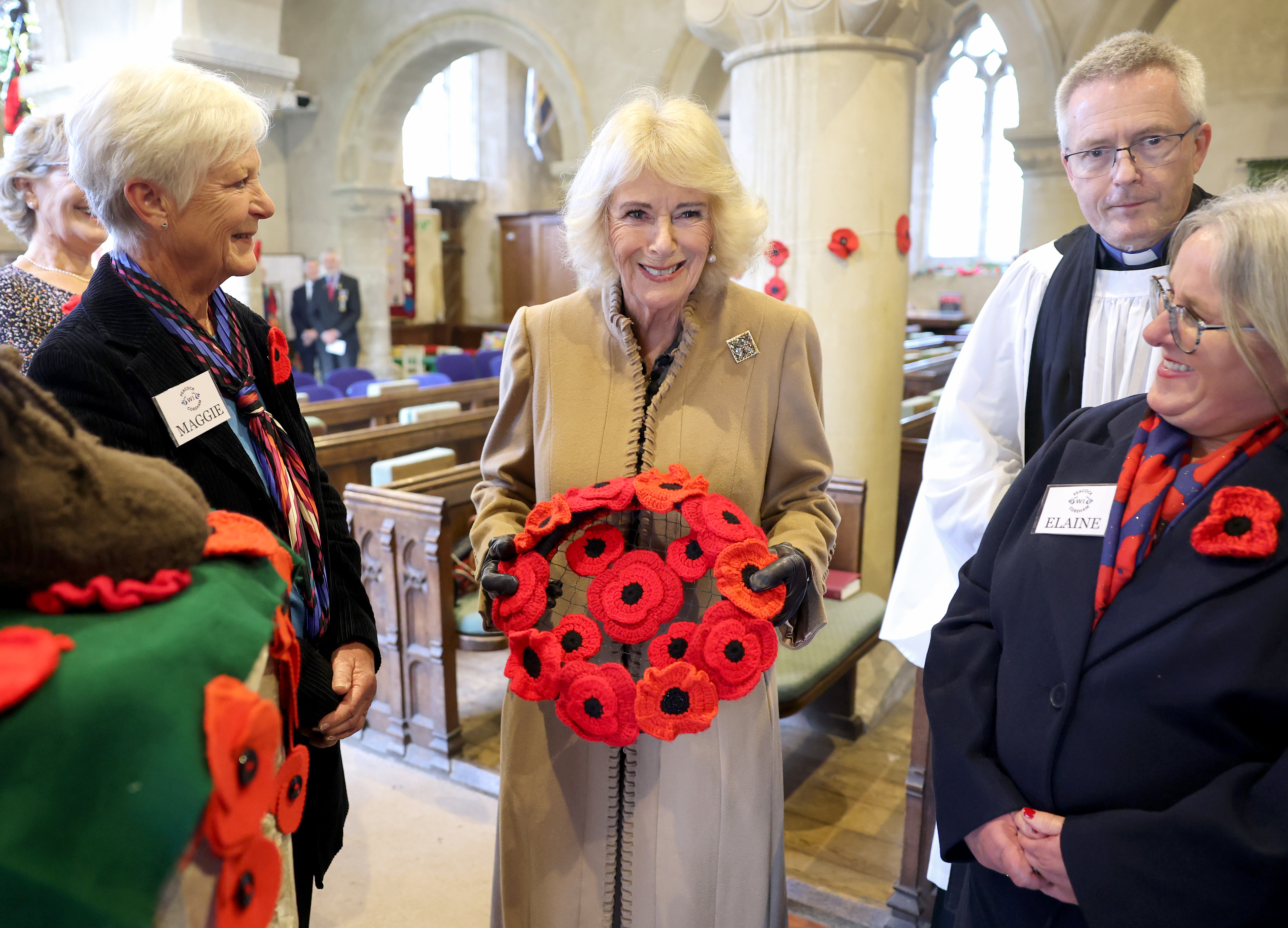 Queen Camilla holds a wreath inside St. Bartholomew's Church during her visit to The Poppy Project, a display of knitted and crocheted poppies created to mark the 80th Anniversary of the end of the Second World War