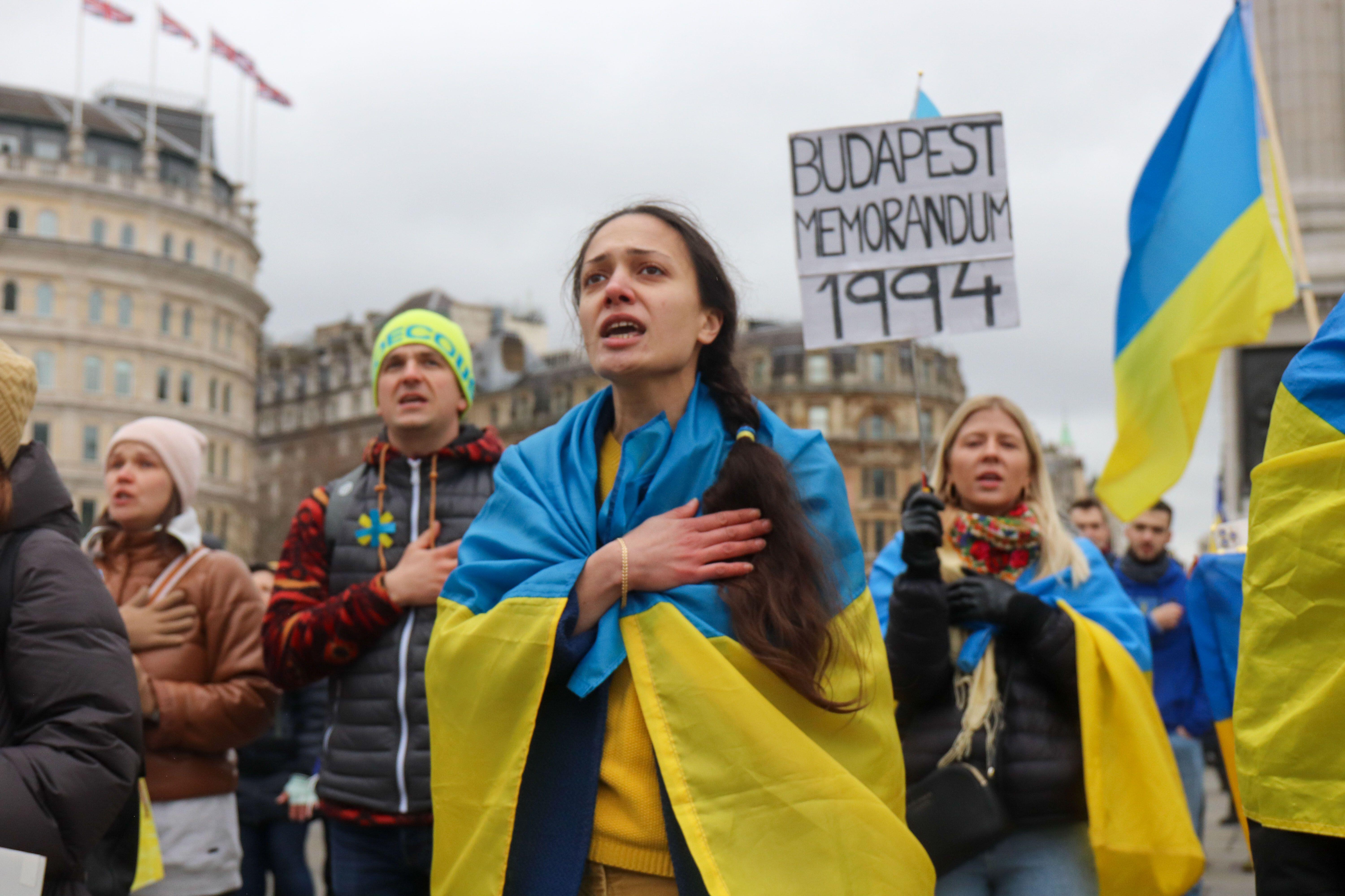 Protesters sing the Ukrainian national anthem during a protest against Russia's invasion of Ukraine on Trafalgar Square. (Picture: Lucy North/Alamy Live News)