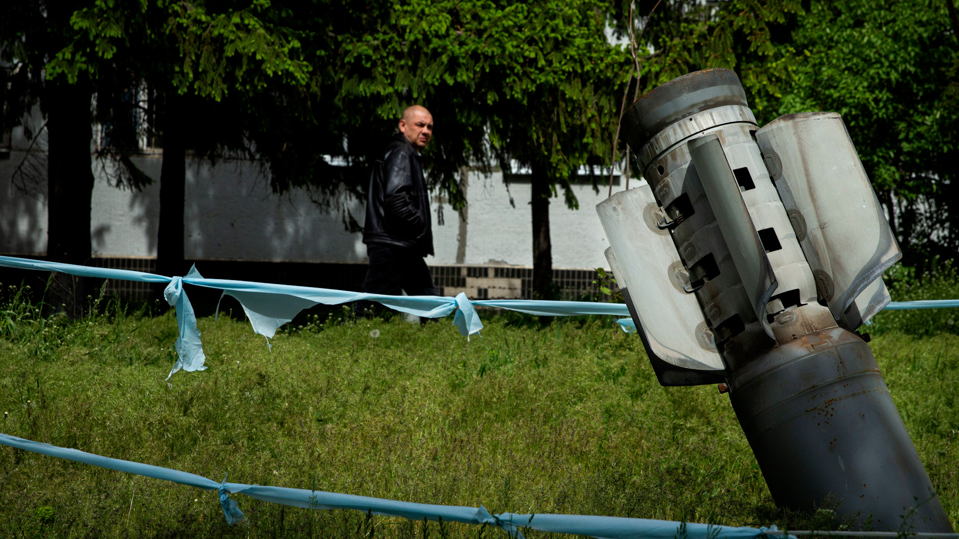 A man walks past an unexploded Russian Smerch cluster bomb that landed in front of a children hospital at Chuhuiv, Ukraine