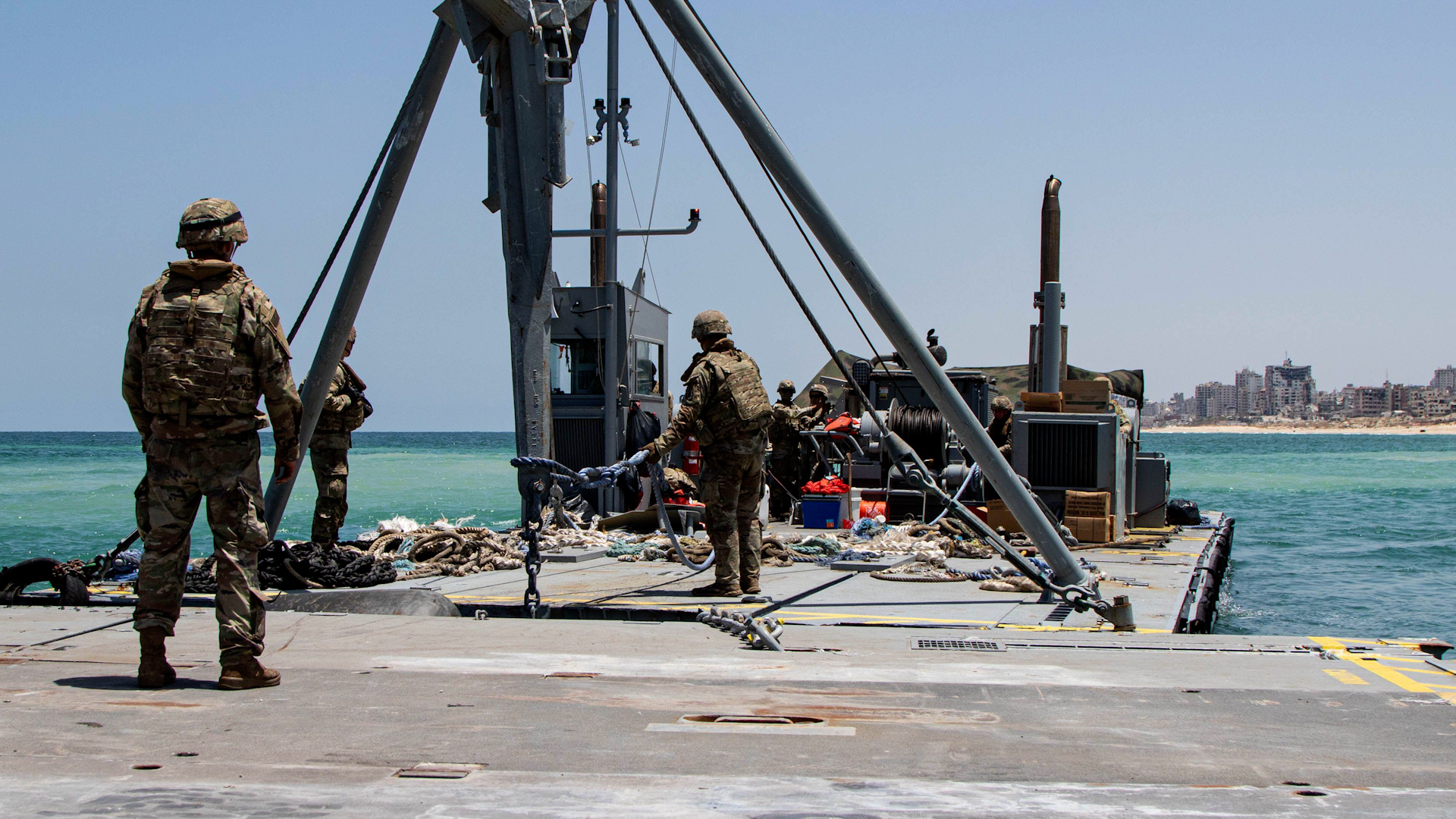 2XJGXKR U.S. Army Soldiers, assigned to the 7th Transportation Brigade (Expeditionary), use a modular warping tug’s crane to drop temporary anchors to stabilize the Trident Pier, Gaza190624 CREDIT Alamy