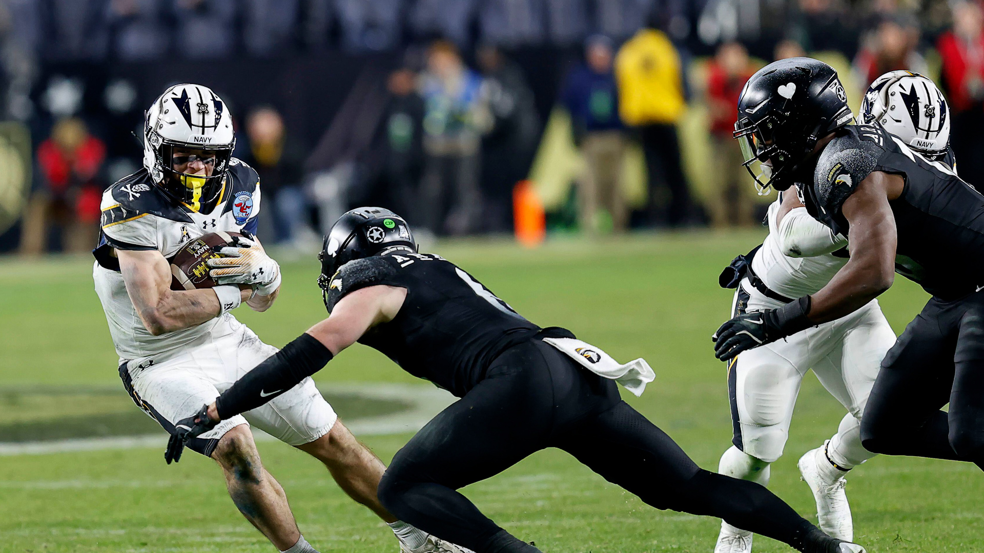 Navy's Eli Heidenreich slides away from Army's Max DiDomenico during a NCAA football game between the United States Naval Academy and the United States Military Academy
