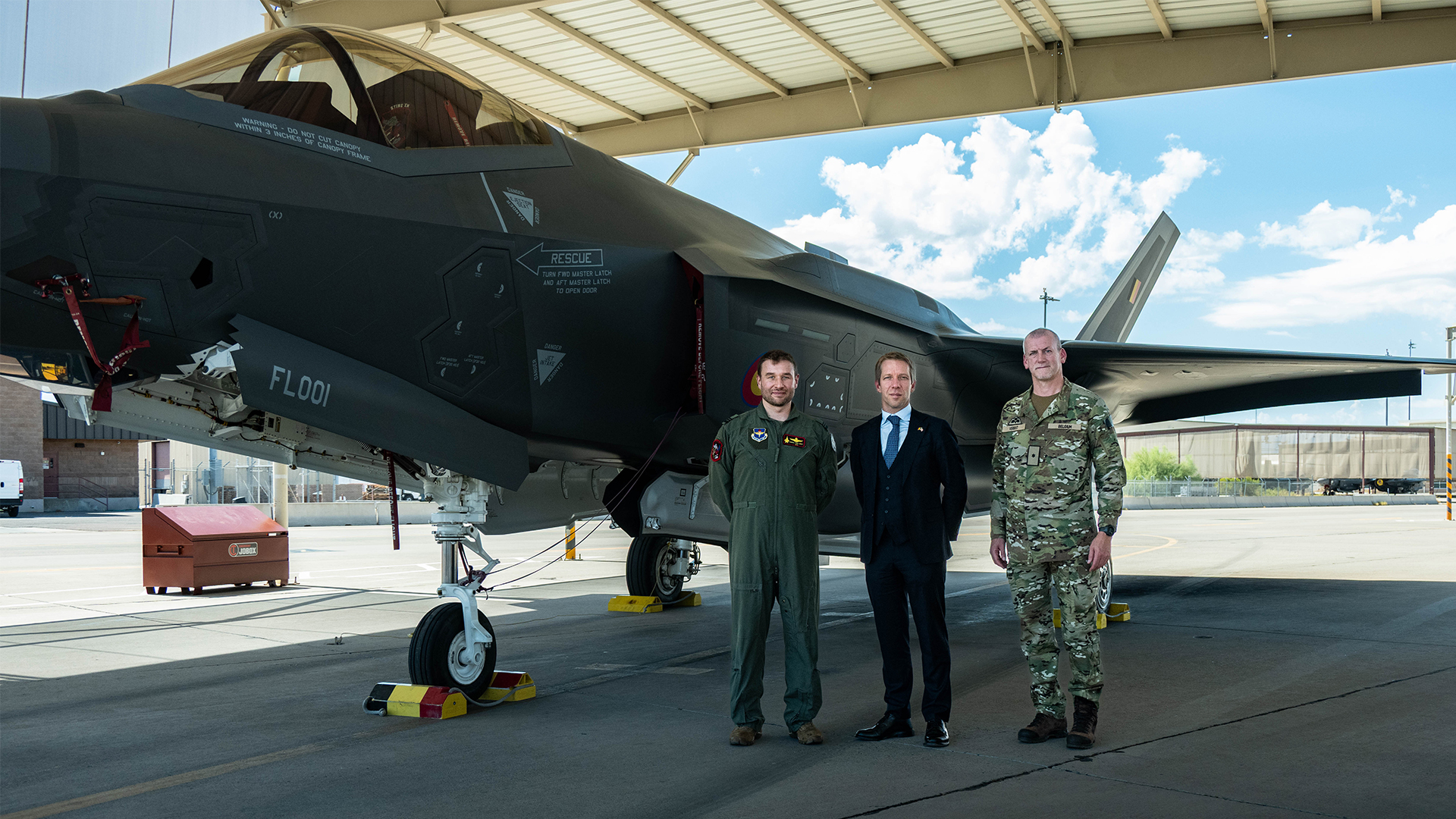 A Belgian air force officer, Belgium's ambassador to the US and the Belgian defence attaché inspect an F-35A