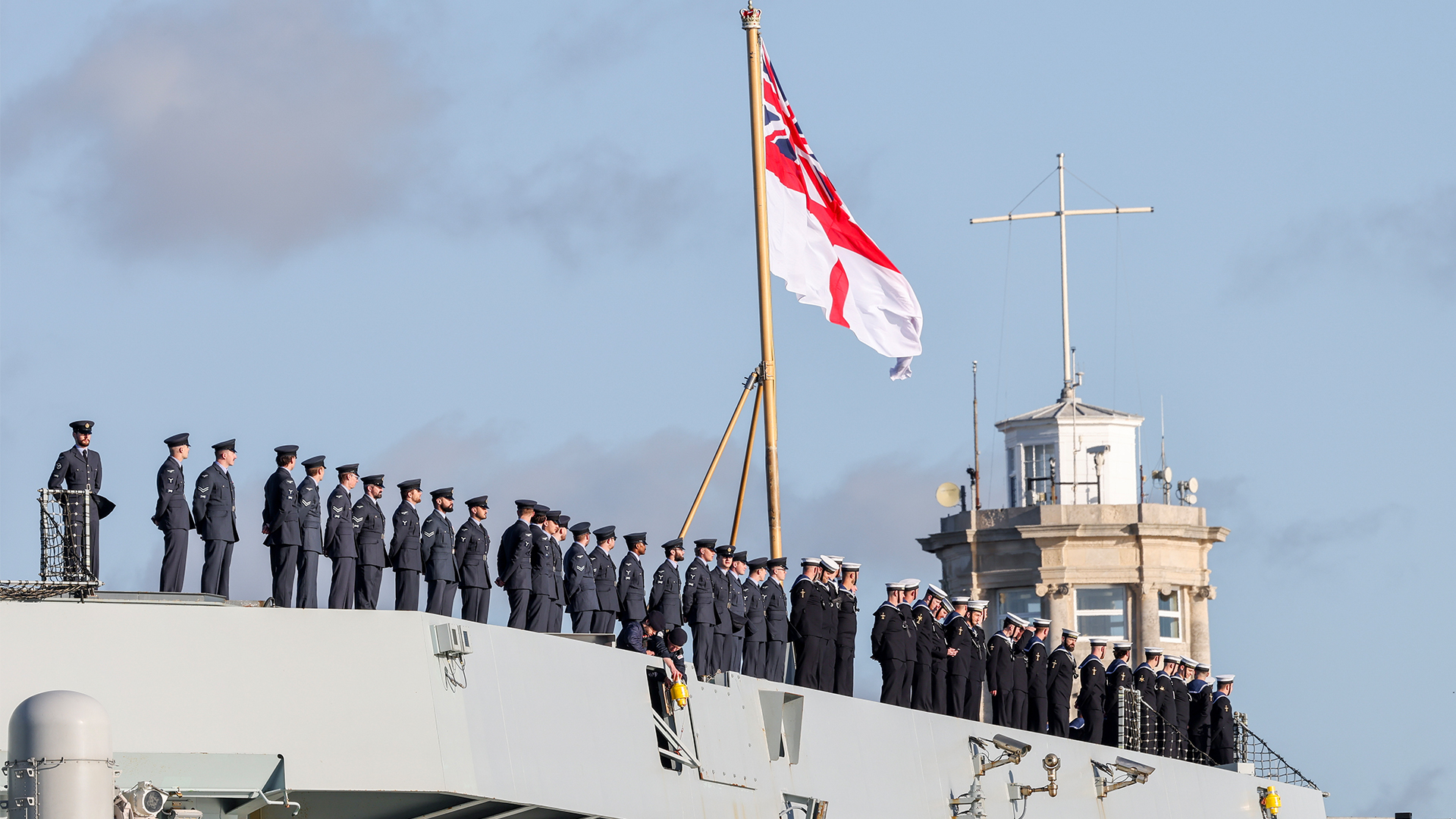 RAF and Royal Navy personnel line up on HMS Prince of Wales, showing the dual-service nature of the carrier and her complement of F-35Bs