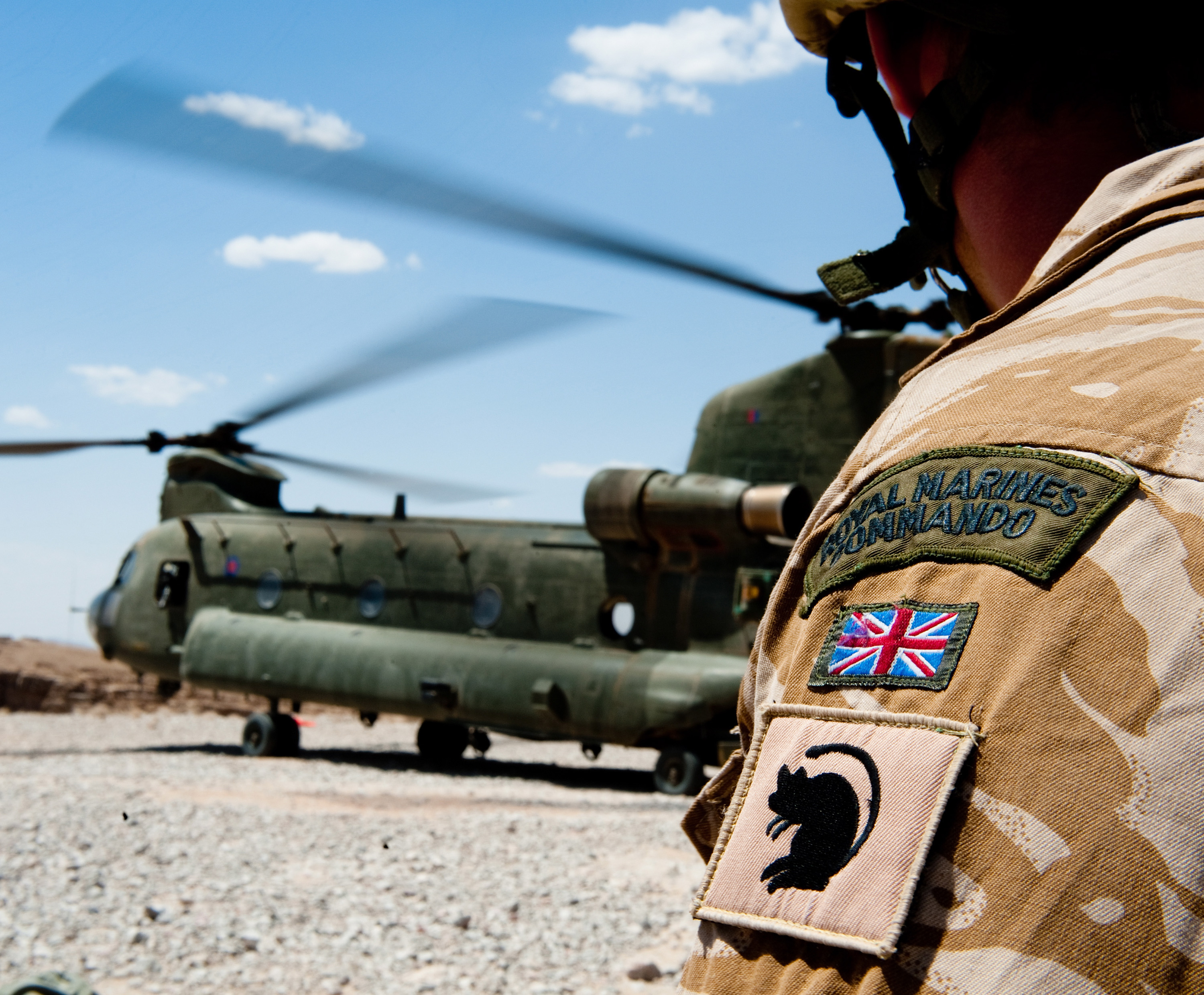 A Royal Marine Commando from 40 Cdo, waits beside a Chinook helicopter on operations in Kajaki, Afghanistan.