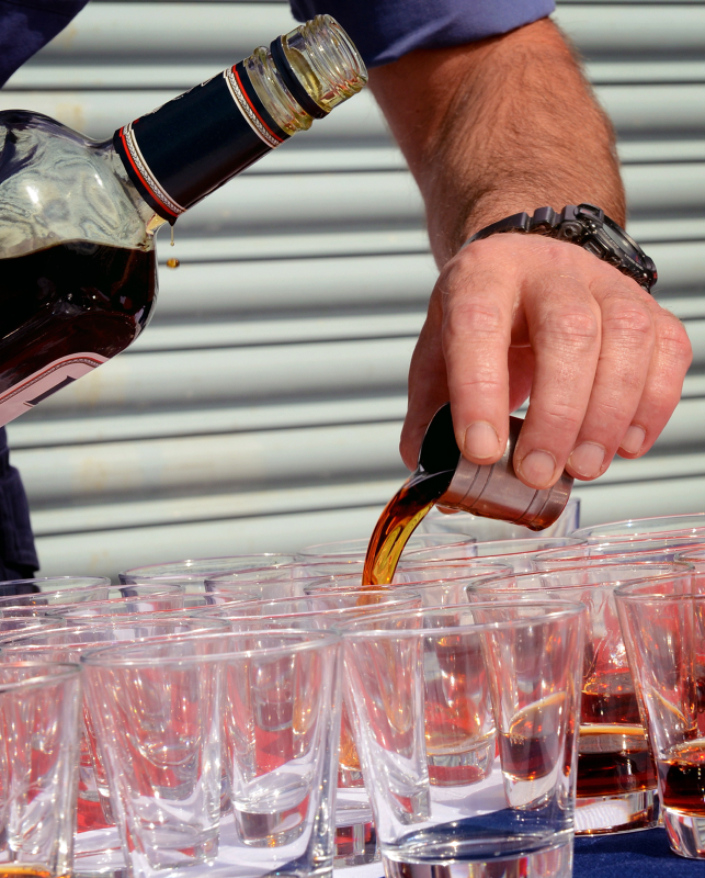 A sailor measures out tots of rum. Credit: Chief Petty Officer Dave Jenkins