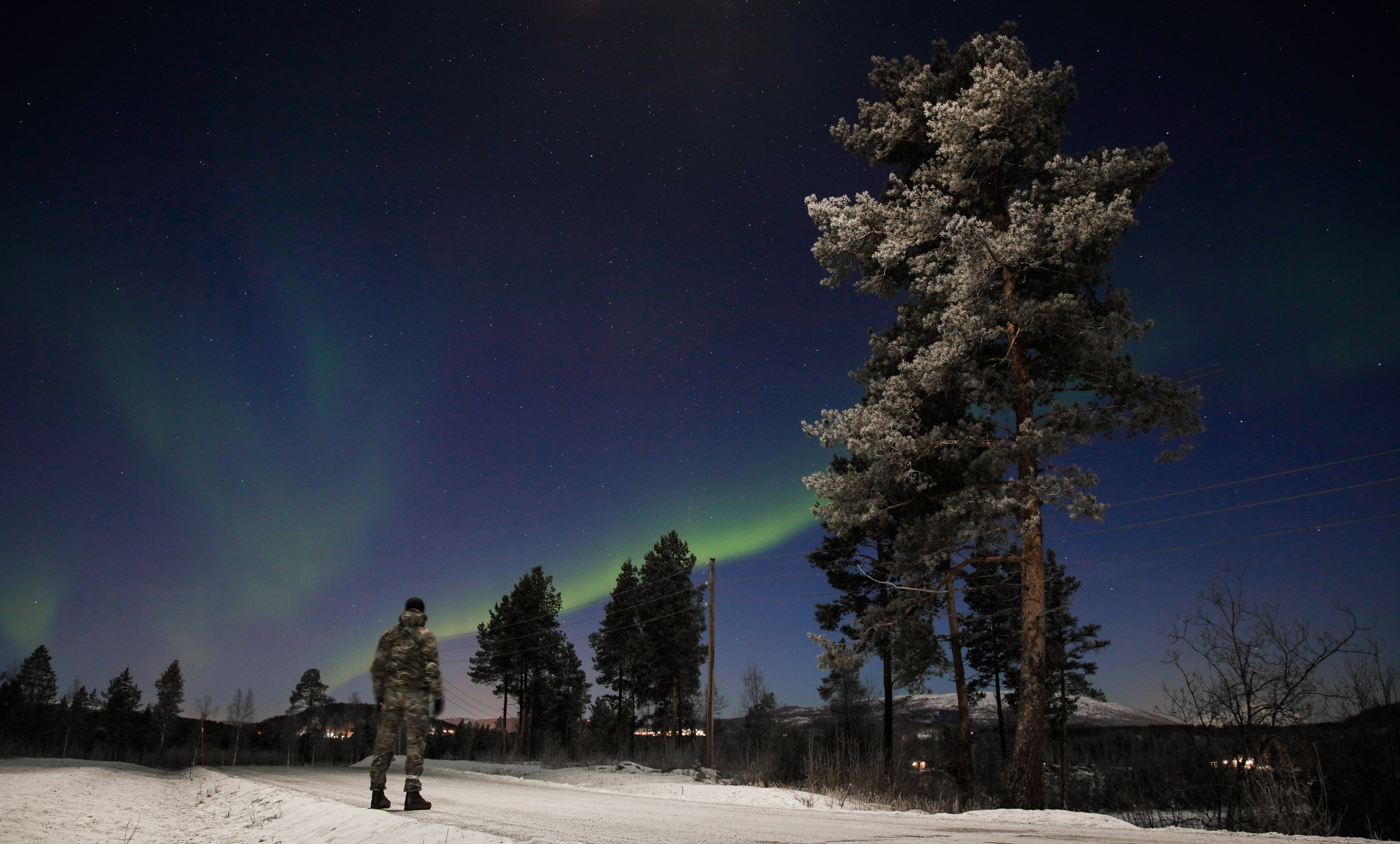 A Royal Marine from 45 Commando stands under The Northern Lights (aurora borealis) during the units Winter Deployment in Bardufoss, Norway.