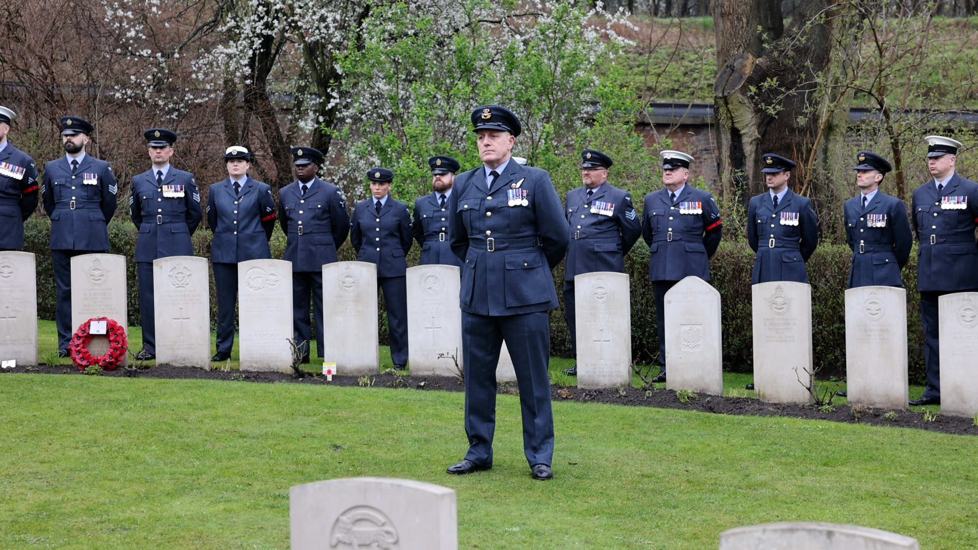 RAF Personnel stand behind war graves