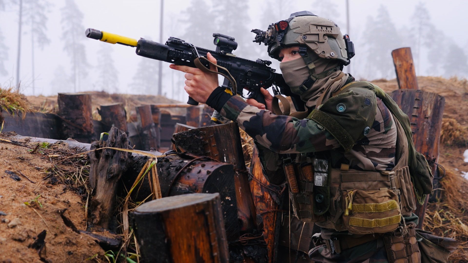 A French infanteer works her way through a trench armed with her HK416 assault rifle