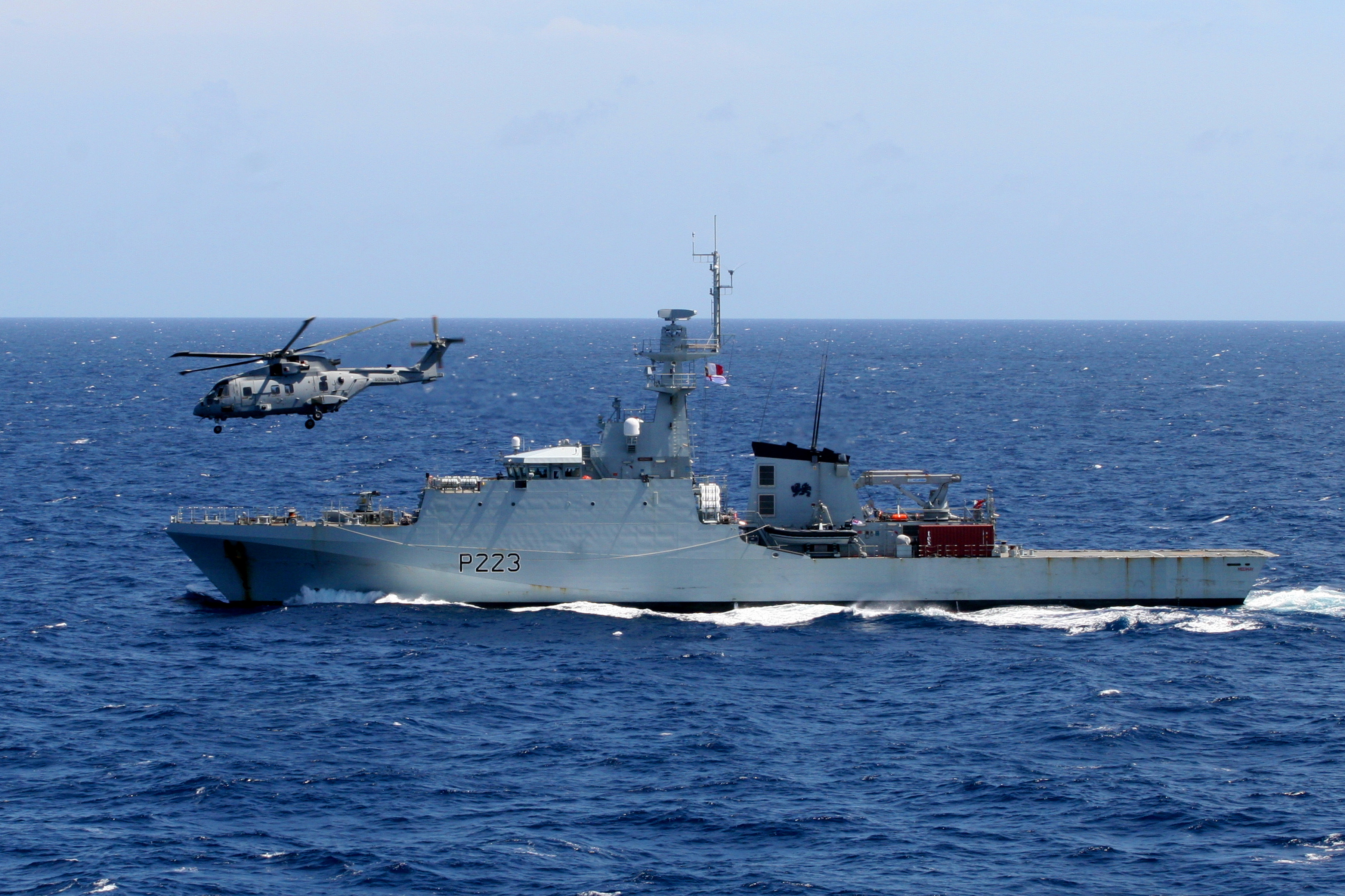 	A Merlin helicopter flies past HMS Medway in the Caribbean