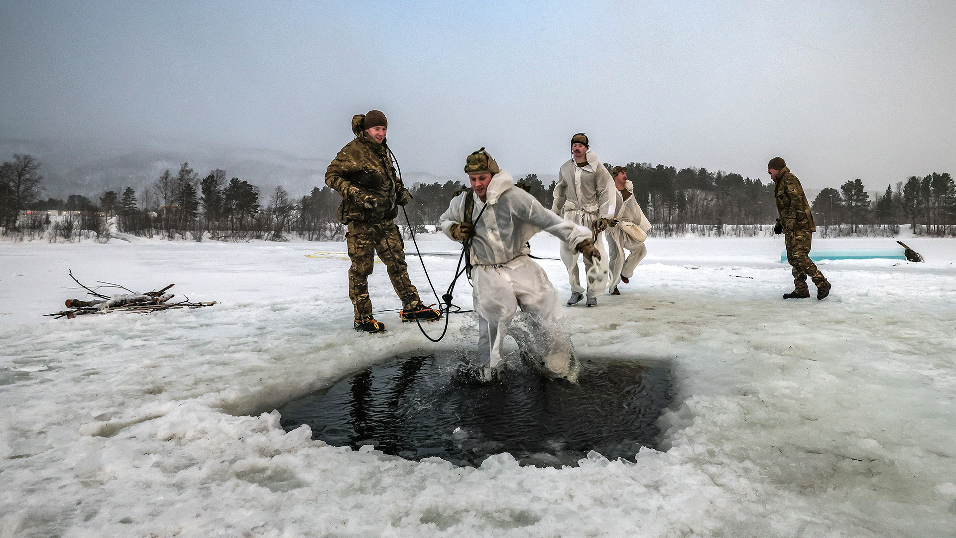 The ice-breaker drill begins with a controlled leap into the water, with the marine tethered to an instructor so he doesn't get trapped beneath the ice