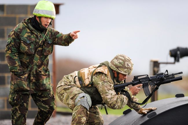 A Tongan soldier is directed by a British colleague during a training exercise at Hythe and Lydd ranges in Kent
