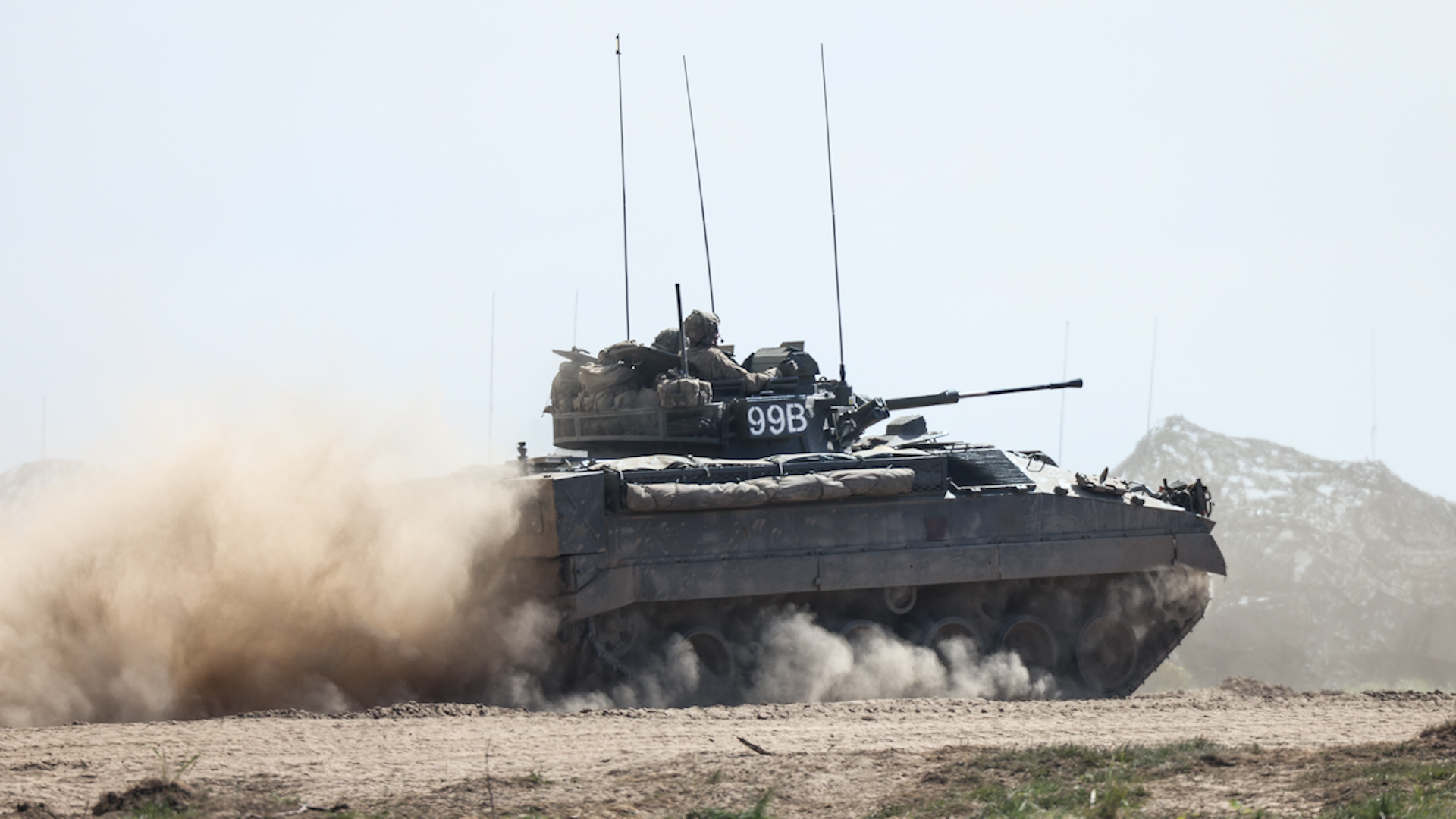A Warrior Infantry Fighting Vehicle drives on dusty track through Drawsko Pomorskie training area