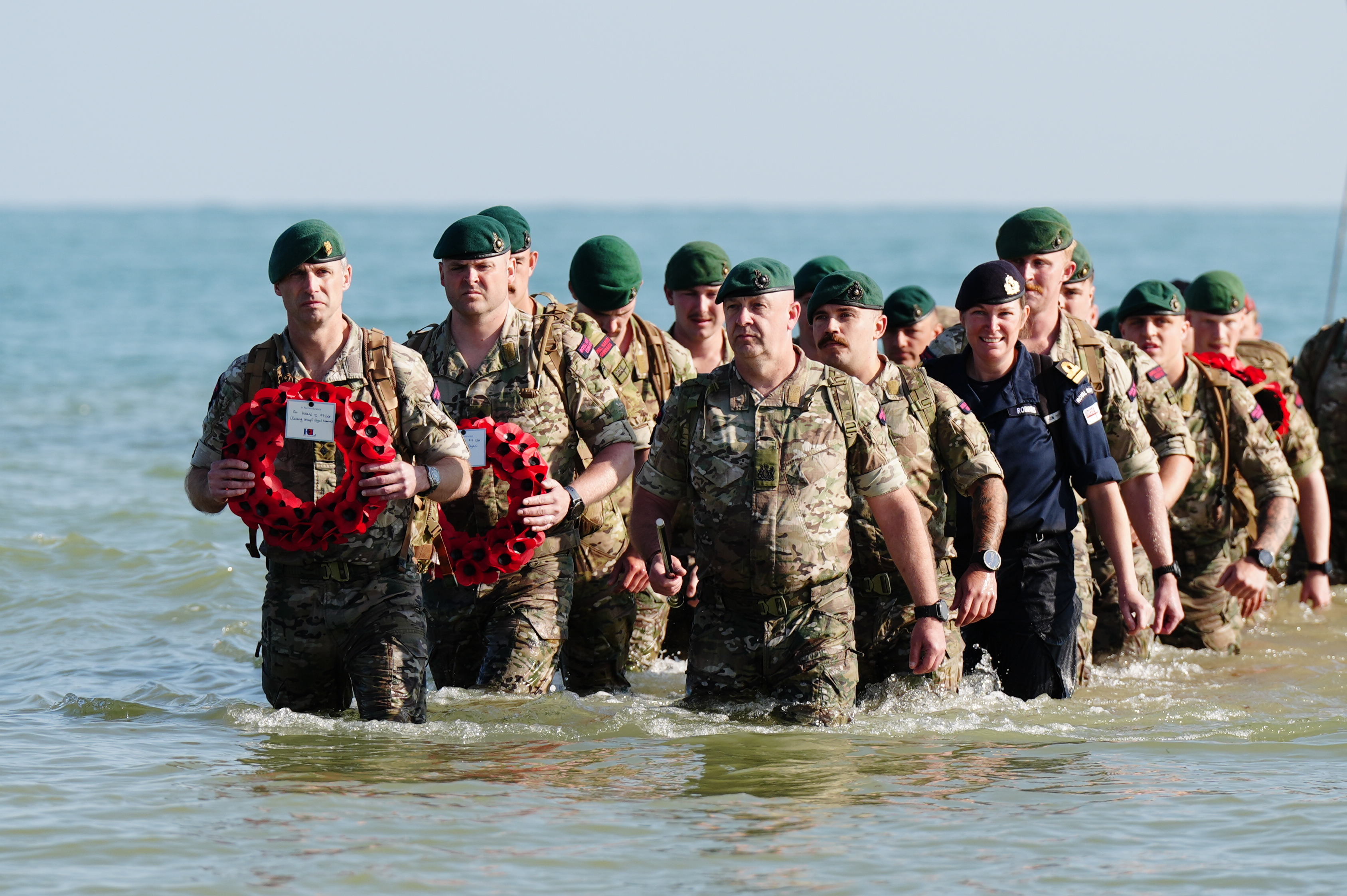 A beach landing by the Royal Marines of 47 Commando and civilians at Asnelles before their annual 'yomp' to Port-en-Bessin