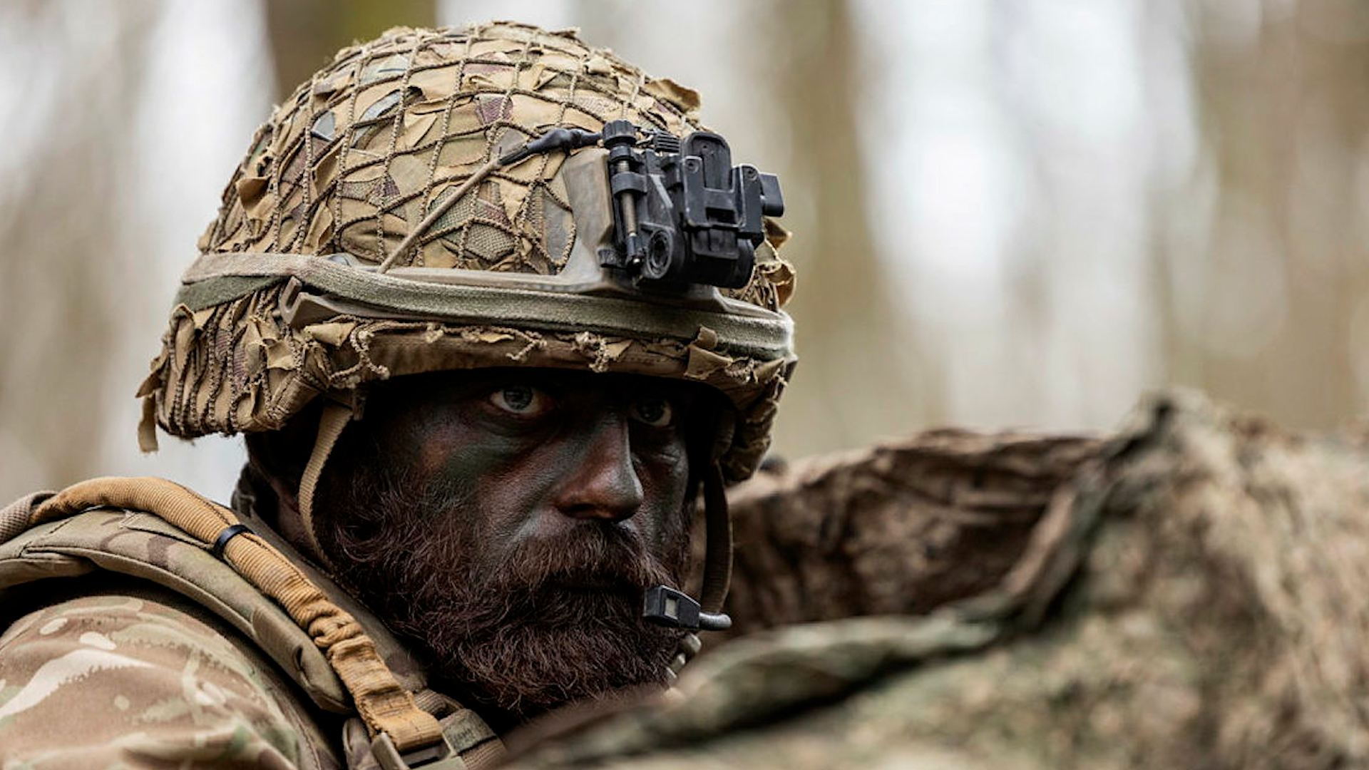A bearded British Army soldier on the Light Recce Commanders course in a French Forest waits in cover for the next phase (Picture: MOD).
