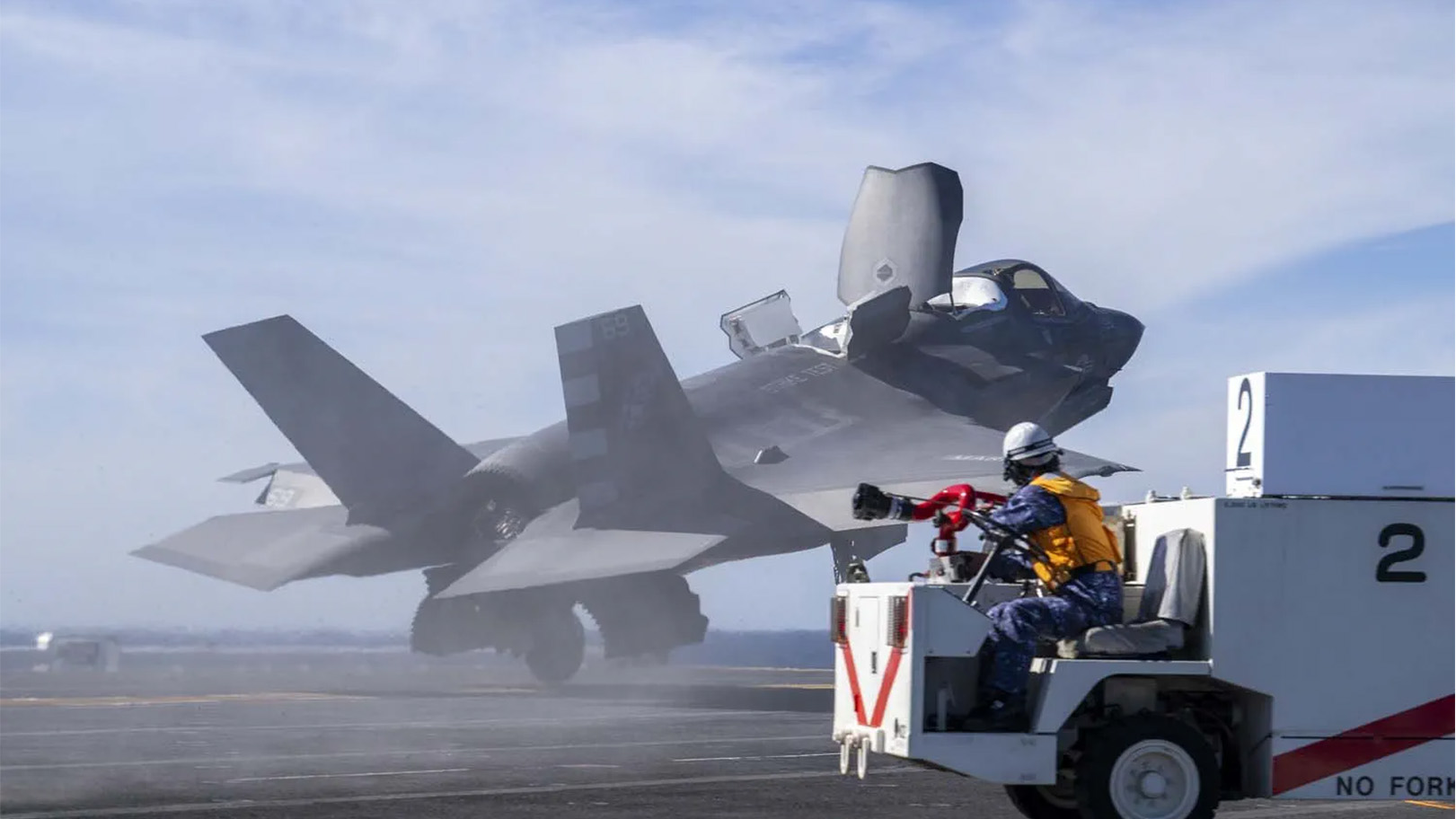 A firefighter watches as an F-35B takes off from the Kaga