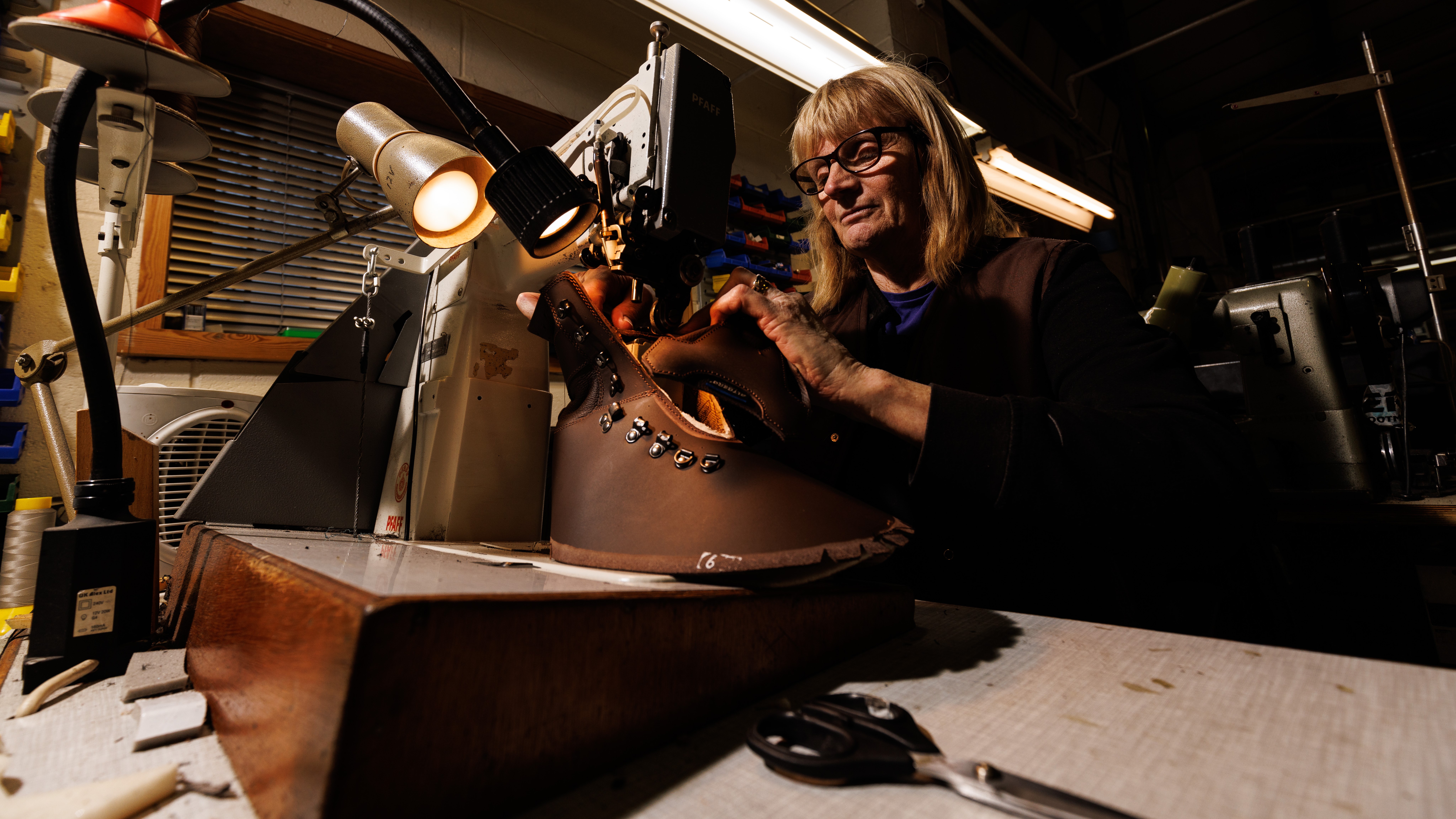 A member of staff uses a sewing machine to sew the seams on the tongue of a Altberg boot 28112022 CREDIT MOD Crown Copyright