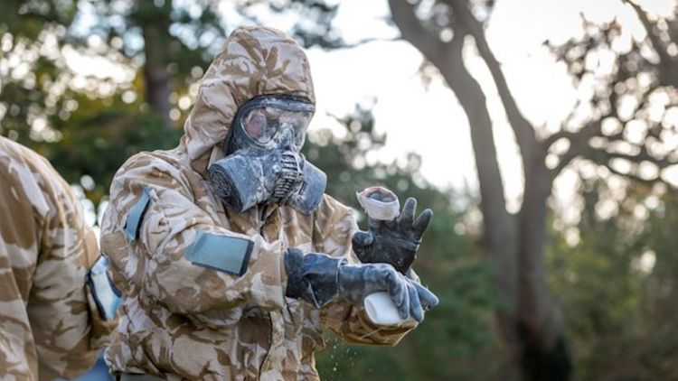 A soldier from 1st Battalion Scots Guards uses decontamination powder after a chemical attack scenario on Ex SHADER TEMPEST as the Scots Guards prepare for deployment on Op SHADER 121120 CREDIT MOD
