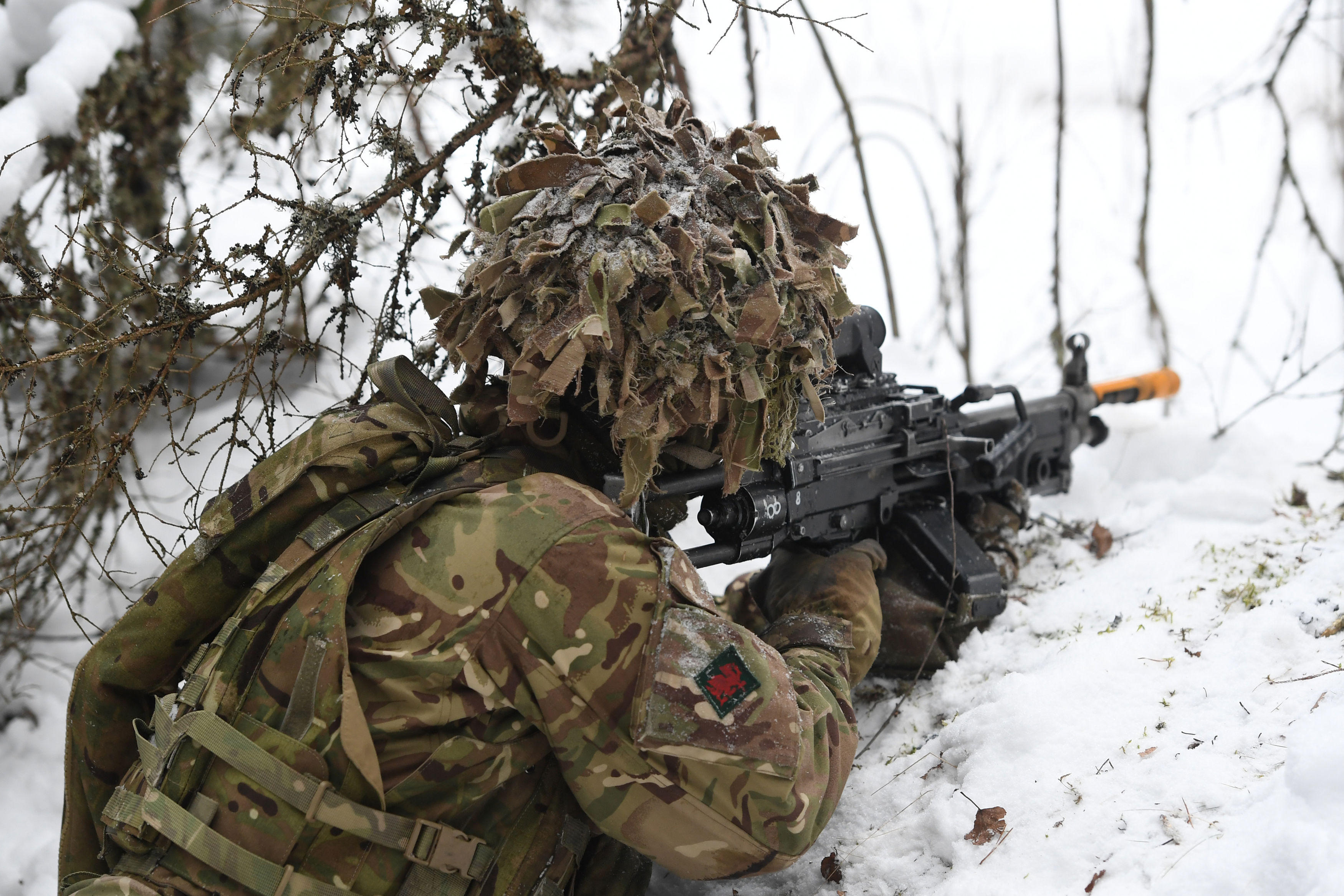 A soldier from 1st Battalion The Royal Welsh looks out from a snow covered trench during Exercise Winter Camp at a training area near Tapa in Estonia
