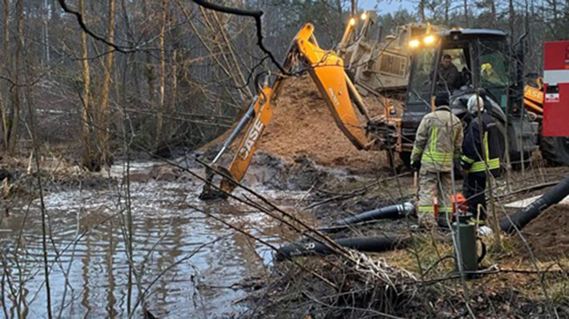 A vehicle works as night sets in to aid the recovery efforts for the four missing soldiers in Lithuania