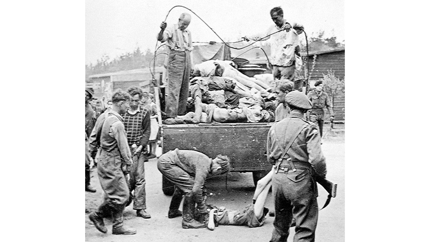 A British soldier guards SS members as they collect the dead at Belsen after its liberation in April 1945 CREDIT National Army Museum