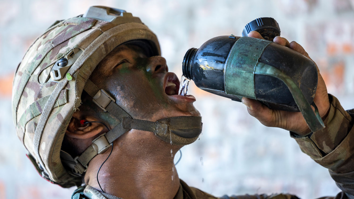A member of 1st Bn The Royal Gurkha Rifles drinking water from his canteen while on Exercise ULU WARRIOR in the Brunei jungle in June 2024 CREDIT Crown Copyright